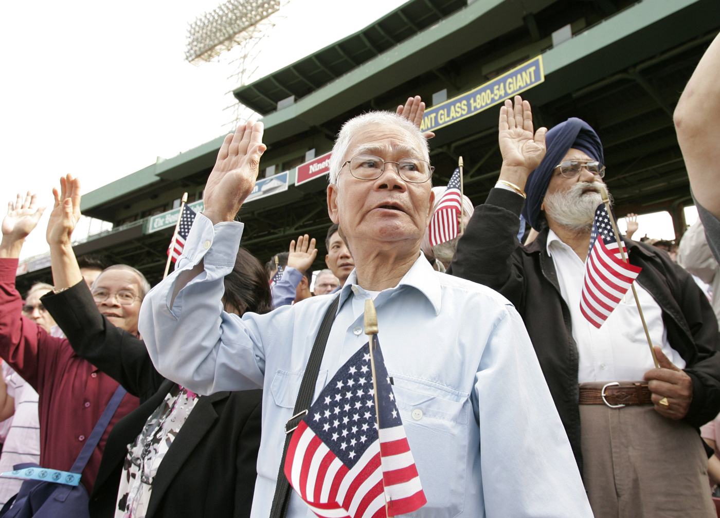 Older Asian man with an american flag in a stadium